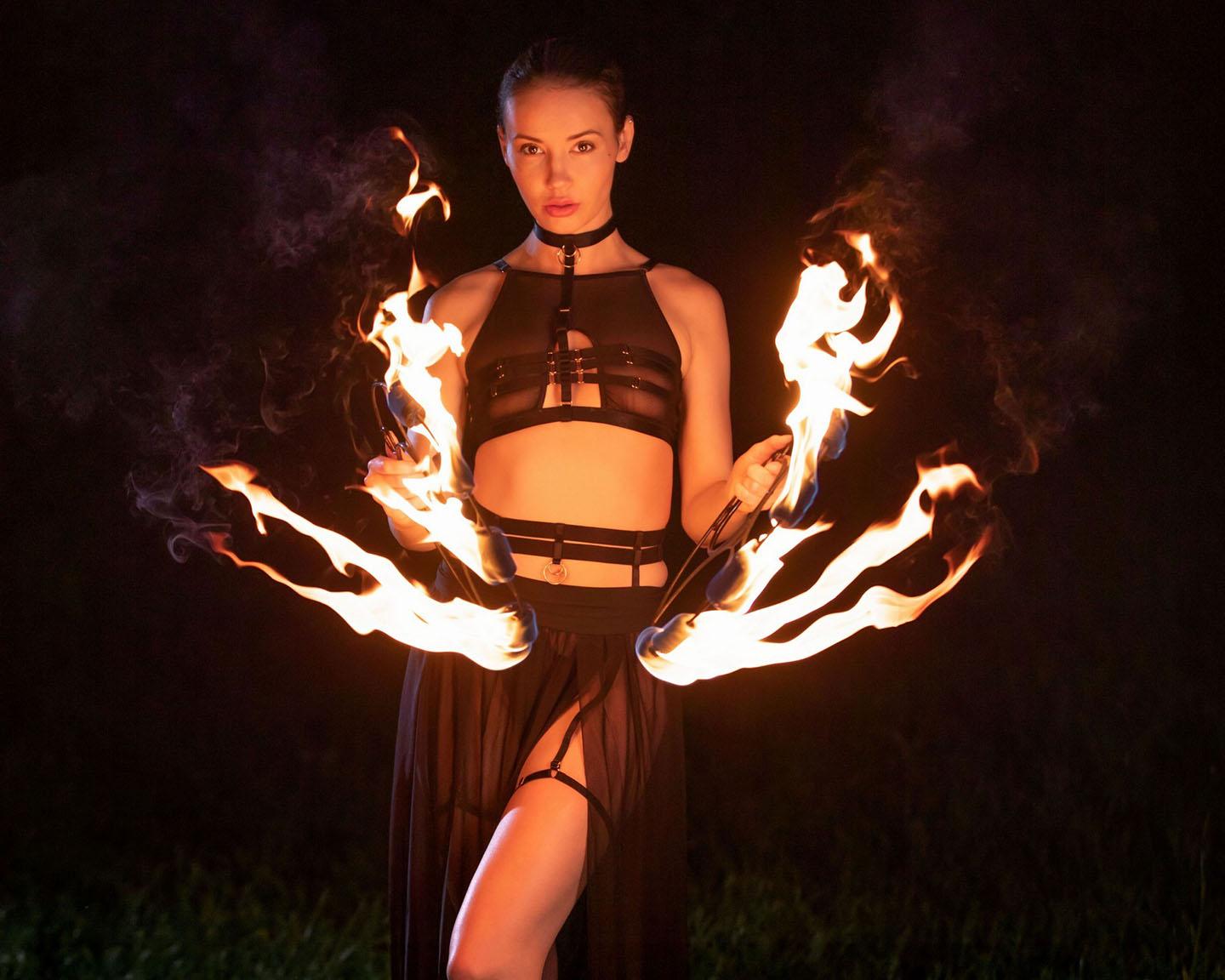 Playboy International (Elilith Noir in Playing with Fire): Elilith Noir returns to Playboy Plus for the first time this year with a pictorial demonstrating one of her unique talents. On set with fire in both hands, Elilith shows off her skills as the photographer, David Merenyi, captures her.